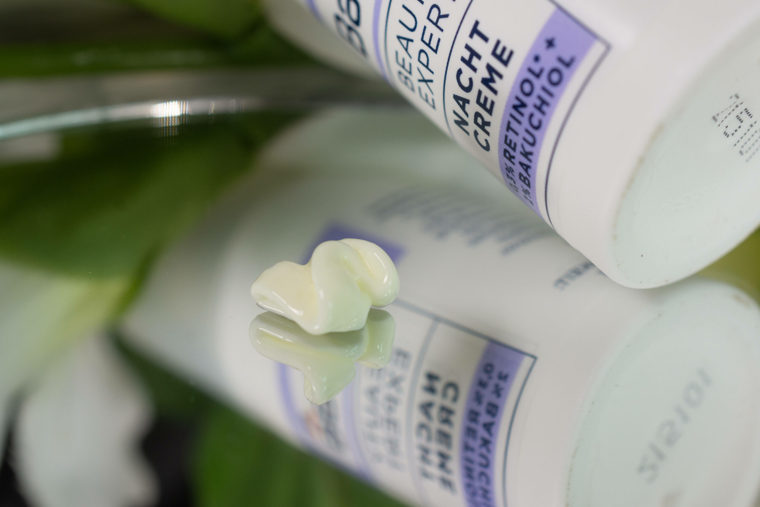 Close up of the Balea Beauty Expert Night Cream on a mirrored surface. It is a slightly yellow cream.