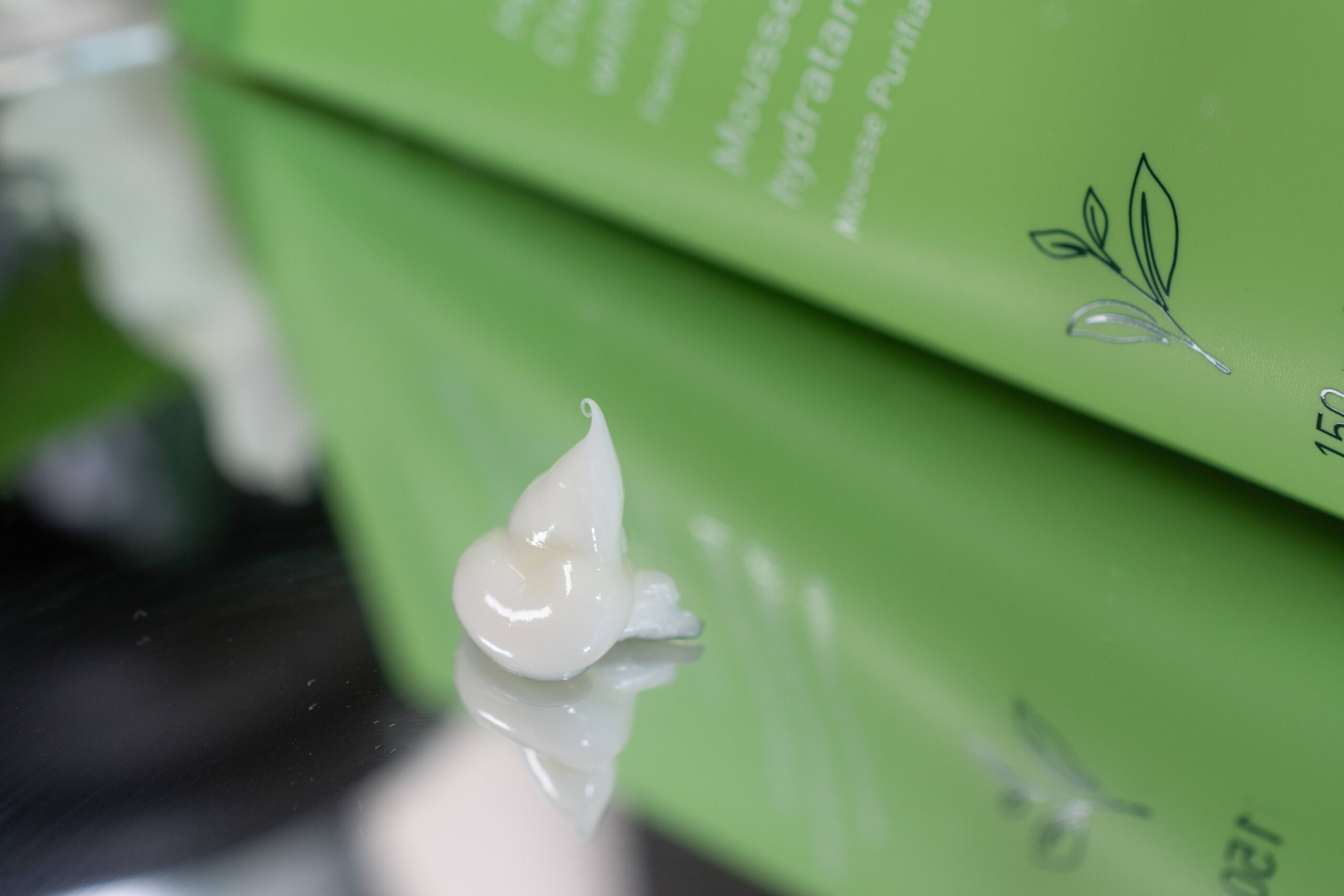 Close up of the innisfree Hydrating Cleansing Foam on a mirrored surface. It looks like a firm, white cream.