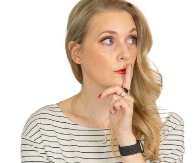 Blonde woman with a finger on her lips