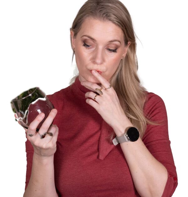 Woman in a red shirt looking at a glass with a collagen supplement inside