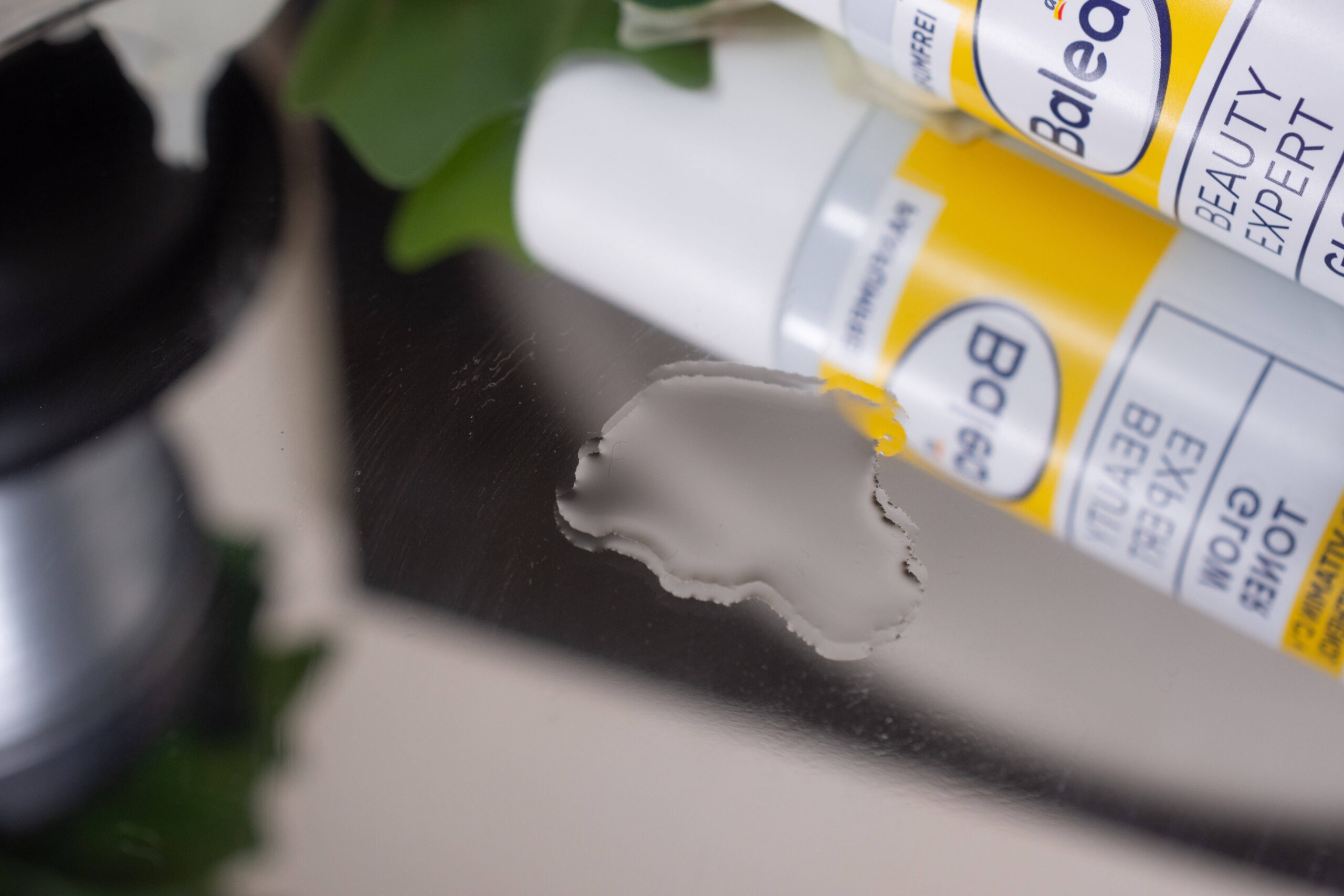 Close up of the Balea Beauty Expert Glow Toner on a mirrored surface, looking like water