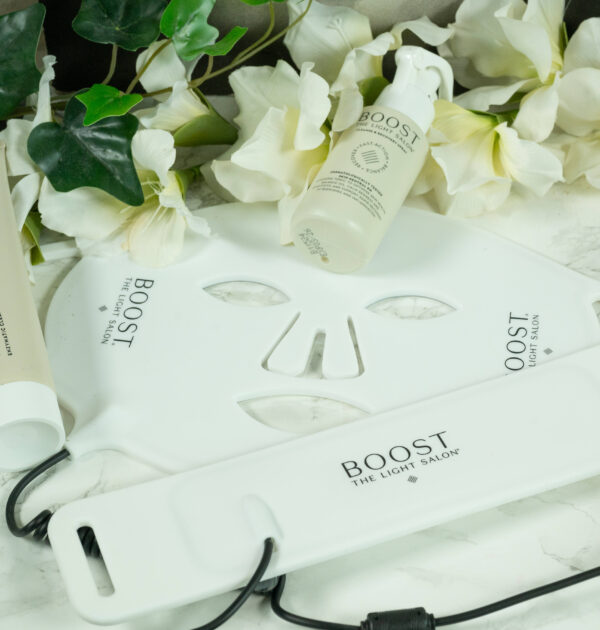 The Light Salon Boost LED mask, LED collar, Cleanse and Recovery Spray and Enzymatic Cleanser and Mask lying on a marbled surface