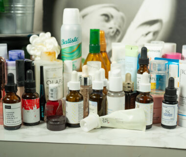 Many empty beauty products lined up before a dark products
