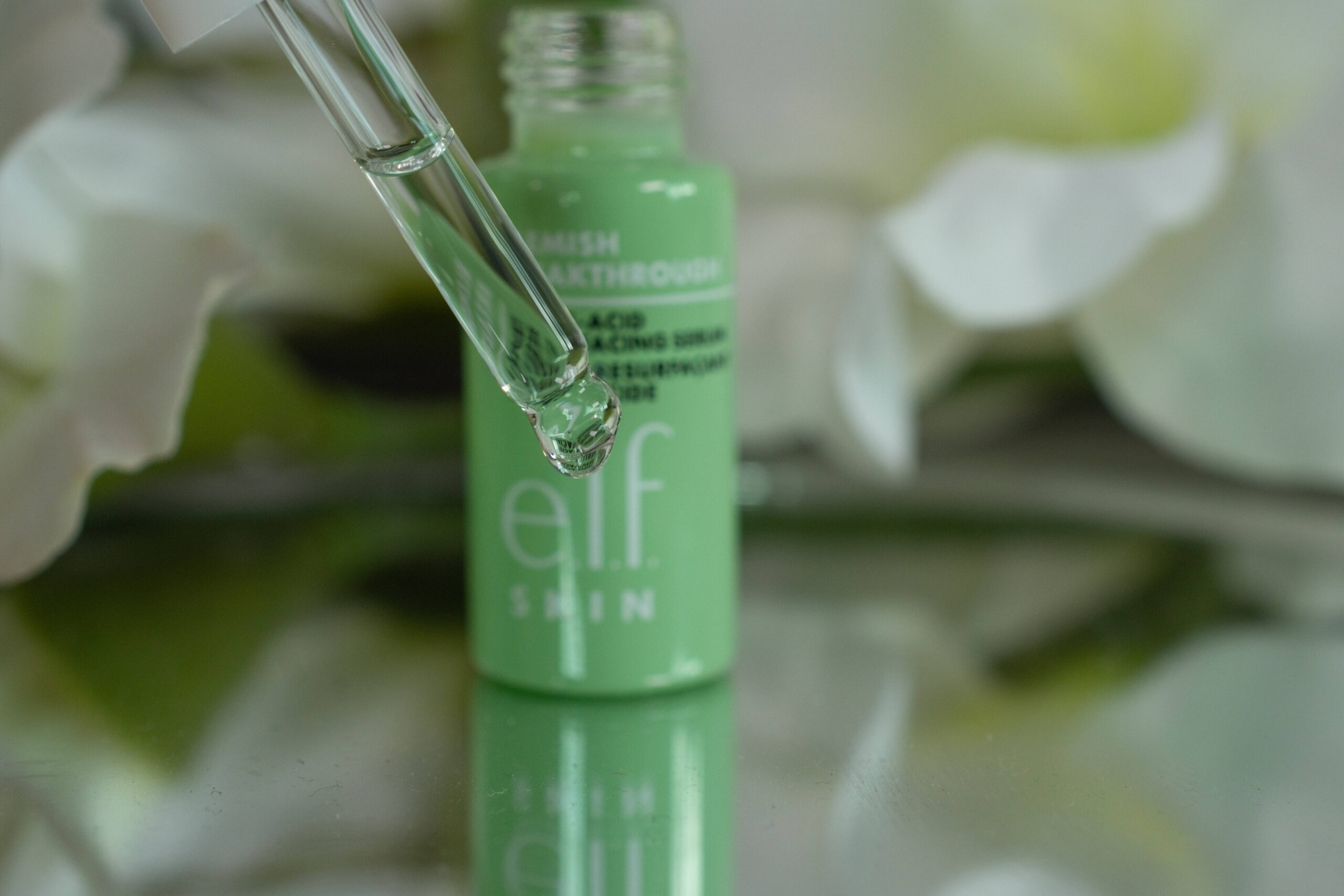 Close up of the e.l.f. Blemish Breakthrough Triple Acid Resurfacing Serum in a glass dropper, looking like water
